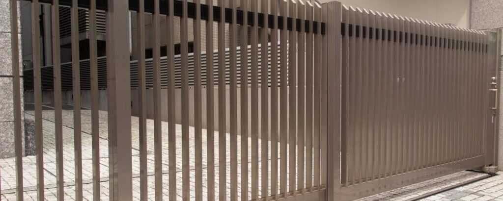 A modern automated sliding gate made of metal, installed at a commercial or residential property for enhanced security and convenience.